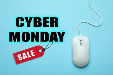 Text Cyber Monday Sale and wired computer mouse on light blue background, top view