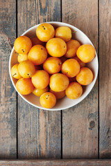 Yellow plums in a bowl.
