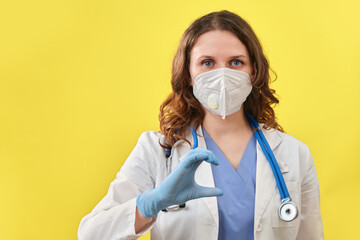 The medic shows the heart sign with his fingers, close-up. Doctor hand in medical glove with the sign of love for patients, concept