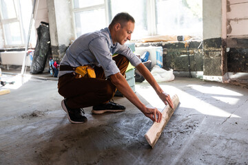 repairman grouting the floor. Renovation of a small business offices