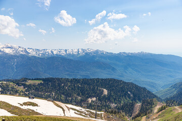 The cable car on the top of mountain of Rosa Khutor. Spring mountain landscape with green mountains...