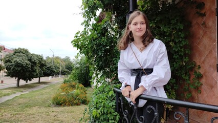 A beautiful girl in a white blouse is walking in the park