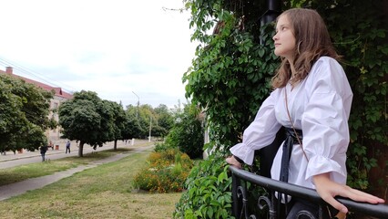 A beautiful girl in a white blouse is walking in the park