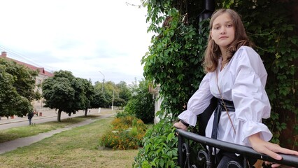 A beautiful girl in a white blouse is walking in the park