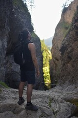 Naklejka premium man looks at a rock wall in the valley