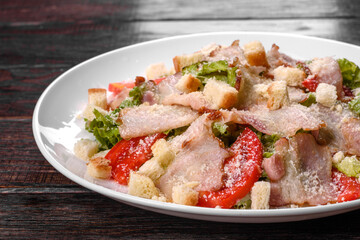 Delicious fresh salad with bacon and tomatoes with spices and greens