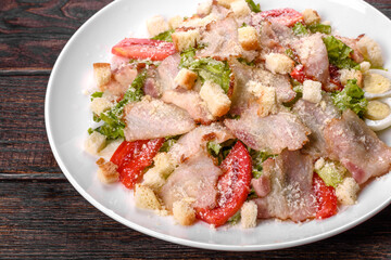 Delicious fresh salad with bacon and tomatoes with spices and greens