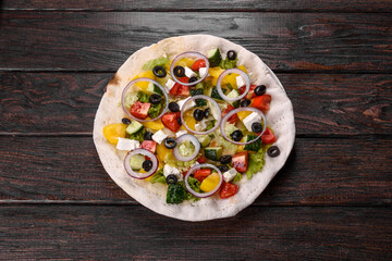 Tasty fresh Greek salad on a pita cooked for a festive table