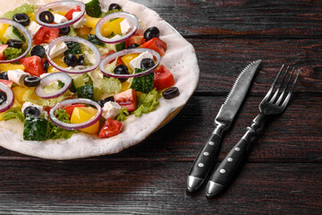 Fototapeta na wymiar Tasty fresh Greek salad on a pita cooked for a festive table