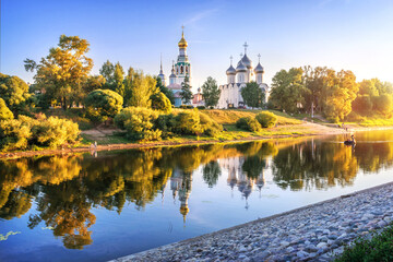 Kremlin temples and reflection in the river in Vologda in the light of a summer evening