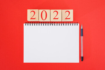 2022 mockup notebook on red background. New Year. plans for 2022, place for text in notepad,