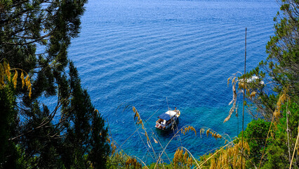 Cilento coast, Scario. Campania, Italy. View of the azure sea, coast and boat.
