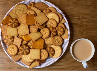 different types of decorated wheat biscuits also called food cracker famous as chai biscuit in india and pakistan served with tea mostly displayed in plate with a cup of tea top view, selective focus
