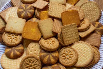different types of wheat biscuits mixed also called food cracker famous as chai biscuit in india and pakistan served with tea mostly displayed on brown background, selective focus