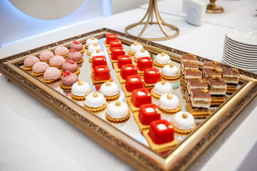 Sweet cakes at a wedding buffet. Catering