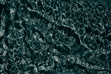 Black transparent clear calm water surface texture with ripples, splashes Abstract nature background. Dark grey water waves in sunlight Copy space Cosmetic moisturizer micellar toner emulsion