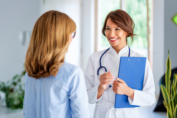 Female doctor consulting her patient while standing in doctor's office