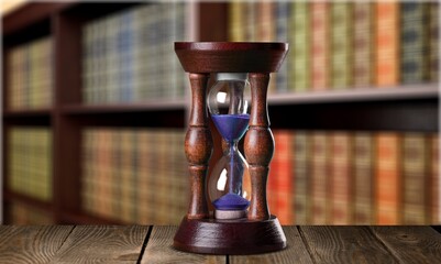 Antique hourglass and collection of old books, history and knowledge concept