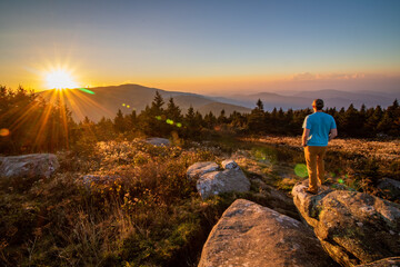 A hiker observing the sunset on the Blue Ridge Mountains in North Carolina