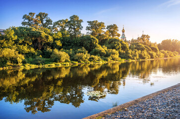Kremlin temples and reflection in the river in Vologda in the light of a summer evening