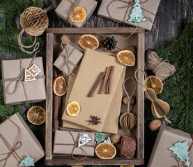 Wrapping rustic eco Christmas packages with brown paper and string on dark background
