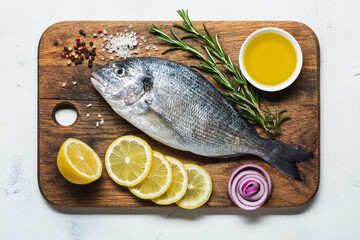 Fresh dorado on a cutting board with lemon and spices.