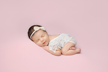 Newborn girl on a pink background. Photoshoot for the newborn.. A portrait of a beautiful, newborn...