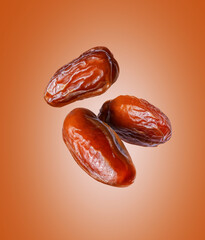 Three dried dates close up in the air