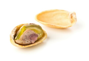 Macro of single salted, roasted green pistachio nut over white background, healthy food snack