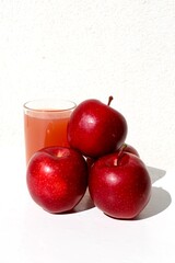 glass of red apple juice and apple in the white background