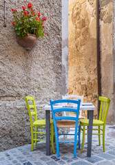 table and color chairs in street cafe in italian city Bolsena
