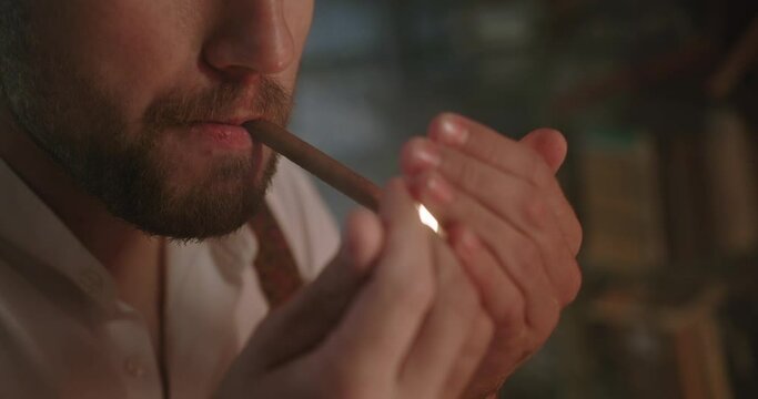 Close up of a cigarette smoking a brutal bearded man in a dark room with documents and contemplating a criminal case