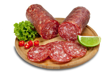 Salame tipo italiano fatiado na tábua de madeira com decoração de alface, pimenta vermelha e limão.