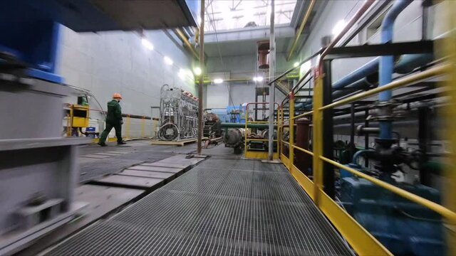Motion across workshop with different new large compressors and working employees at contemporary production plant