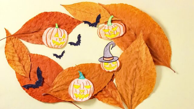 Stop motion animation. A Halloween-themed cartoon with paper pumpkins, leaves and bats.