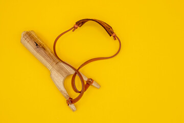Wooden slingshot isolated on yellow background