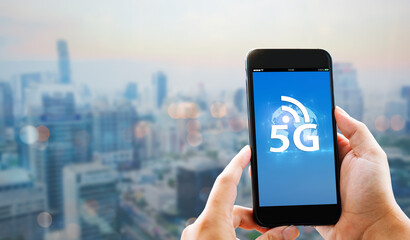 5G high speed new generation networks connection concept.Man hands holding mobile phone on blurred city as background