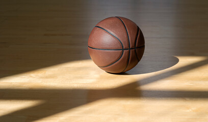Obraz premium Basketball court wooden floor with professional brown leather ball and shadows. Horizontal sport poster, greeting cards, headers, website