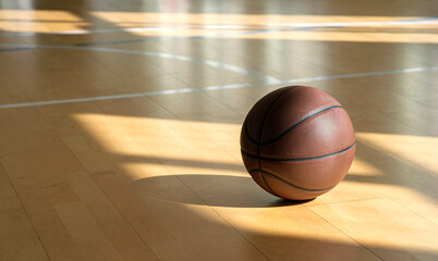Basketball court wooden floor with professional brown leather ball and shadows. Horizontal sport...