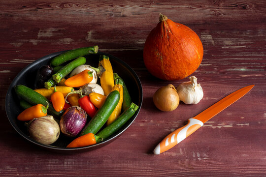 un ensemble de petits et gros légumes avec un couteau pour la cuisine sur une table en bois 