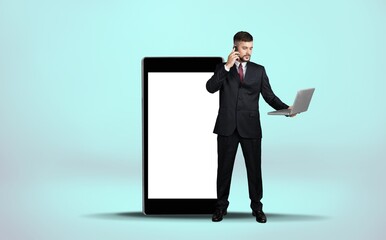 Full length of young guy leaning on giant mobile phone with an empty screen,