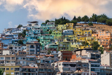 Fototapeta premium Colorful Kusadasi houses on the hill seen through palm leaves, , Aydin, Turkey