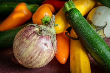 une petite aubergine en gros plan au milieu de petits légumes du potager