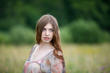 sweet brunette with blue eyes smiles widely in the field