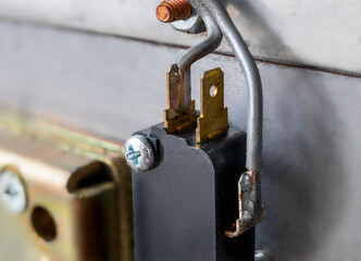 Wires attached to device, close up. Grey thick wires connected to prongs. Electronic or electricity background texture. Selective focus.