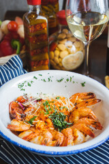 Traditional bright shrimp risotto in a bowl on a table in a restaurant with a beautiful decor in a dark key close-up.