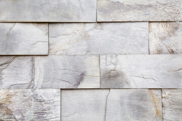 The background of the wall is made of rectangular tiles of natural slate Gray  with a beautiful pattern of stone. Backgrounds texture design.