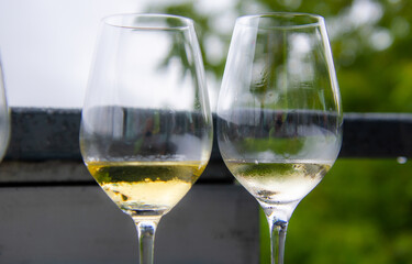 Glass of white wine on a table outside.