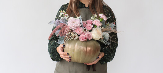 Bouquet of autumn flowers collected in a pumpkin. Floristry for Halloween.	
