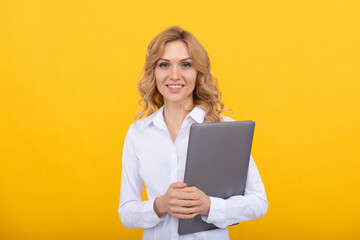 smiling businesswoman in white shirt hold laptop on yellow background, business